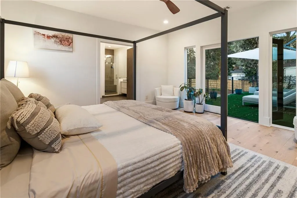 Bedroom featuring access to outside, wood-type flooring, multiple windows, recessed lighting, and ensuite bath
