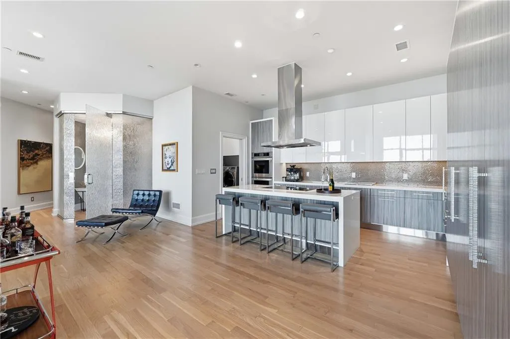 A stunning kitchen featuring an island, waterfall countertops, a spacious and convenient layout, and captivating city views.