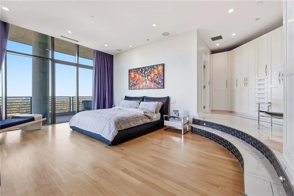 The beautiful primary suite features floor-to-ceiling windows and opens directly onto the second balcony and the City.