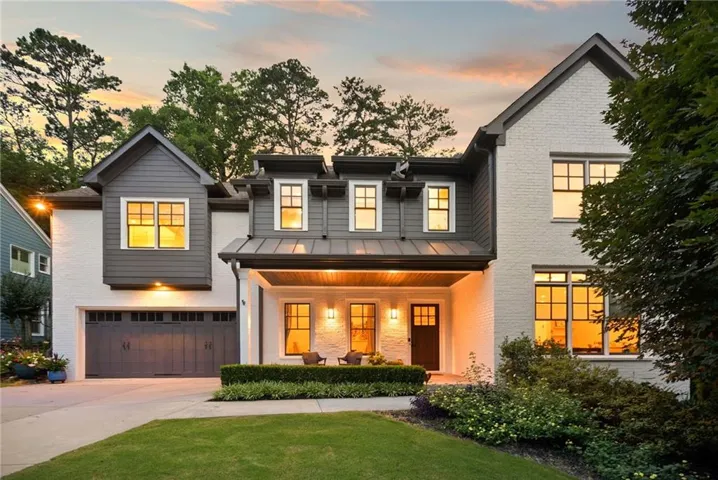 Modern traditional home featuring a white brick and dark siding exterior