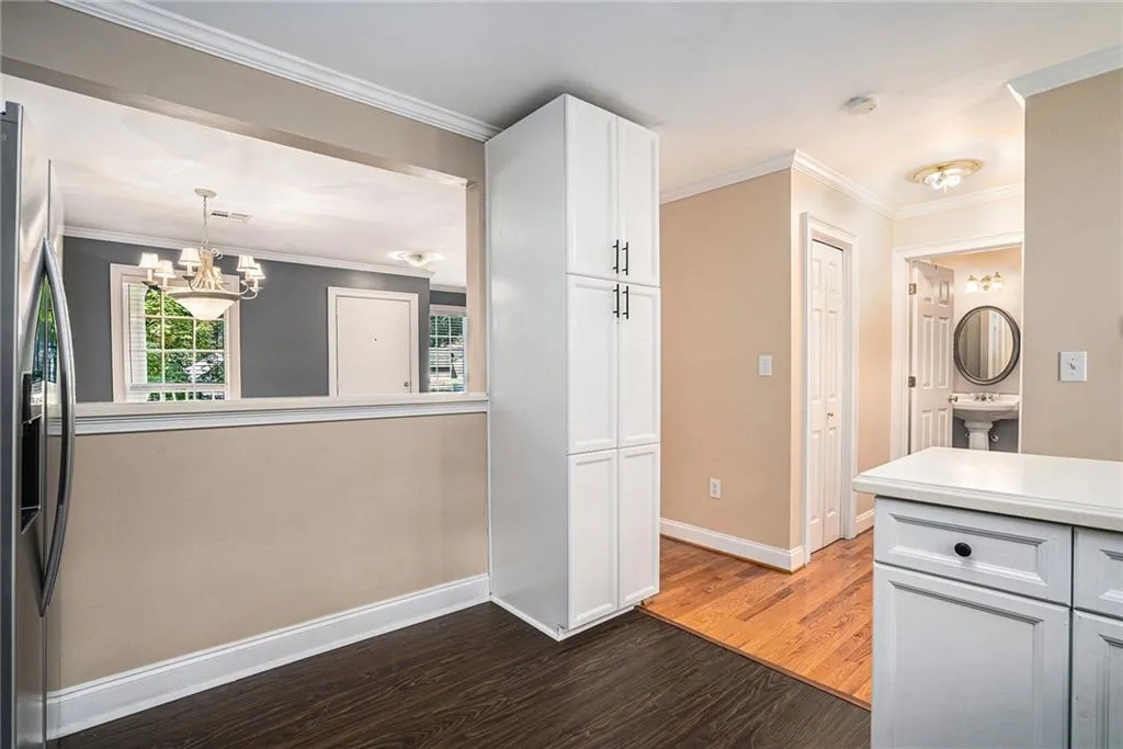 Kitchen featuring decorative light fixtures, hardwood / wood-style flooring, stainless steel fridge with ice dispenser, and crown molding