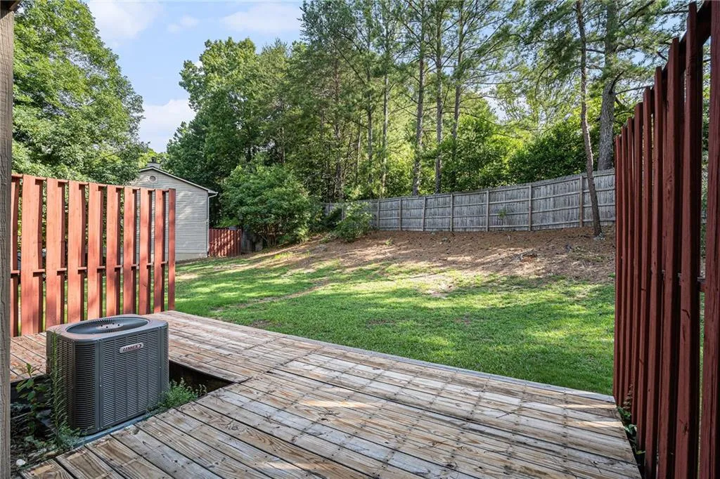 Wooden deck featuring a yard and central AC unit