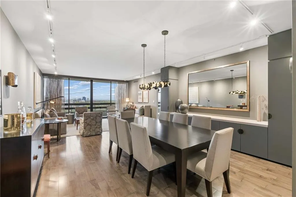 Dining area with rail lighting, expansive windows, and light wood-style flooring