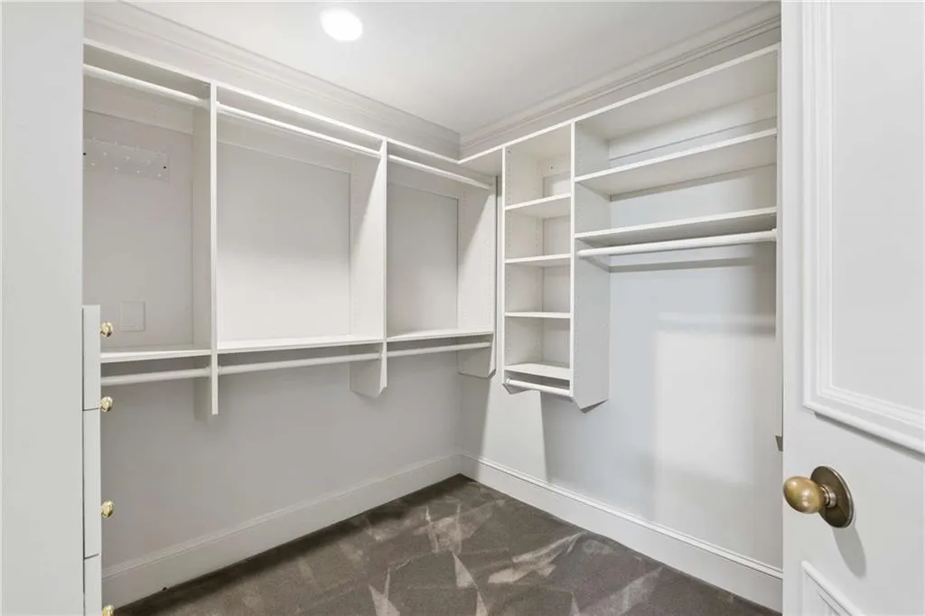 Walk in closet with dark colored carpet