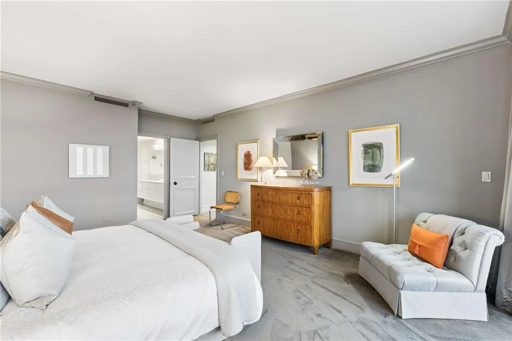 Carpeted bedroom featuring crown molding and ensuite bathroom