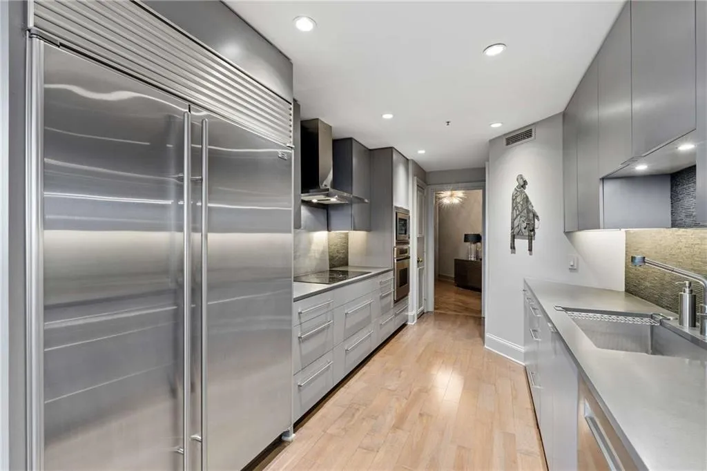 Kitchen featuring gray cabinetry, built in appliances, modern cabinets, light wood-style flooring, and recessed lighting