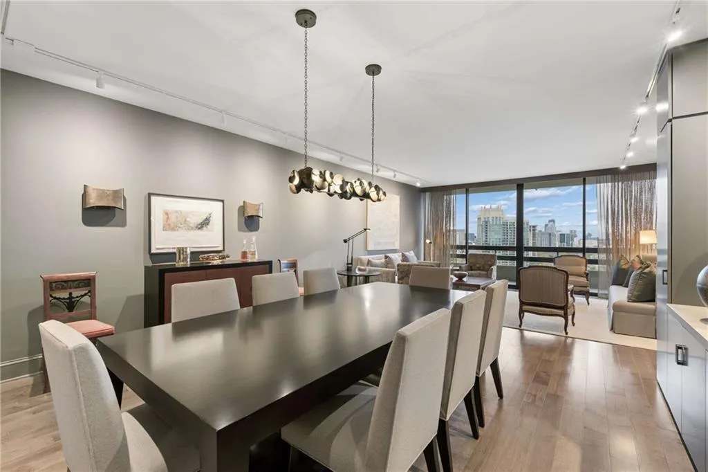 Dining space with track lighting, a skyline view, light wood finished floors, and floor to ceiling windows