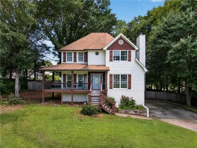 Two-story residence featuring white siding and coordinating brown shutters