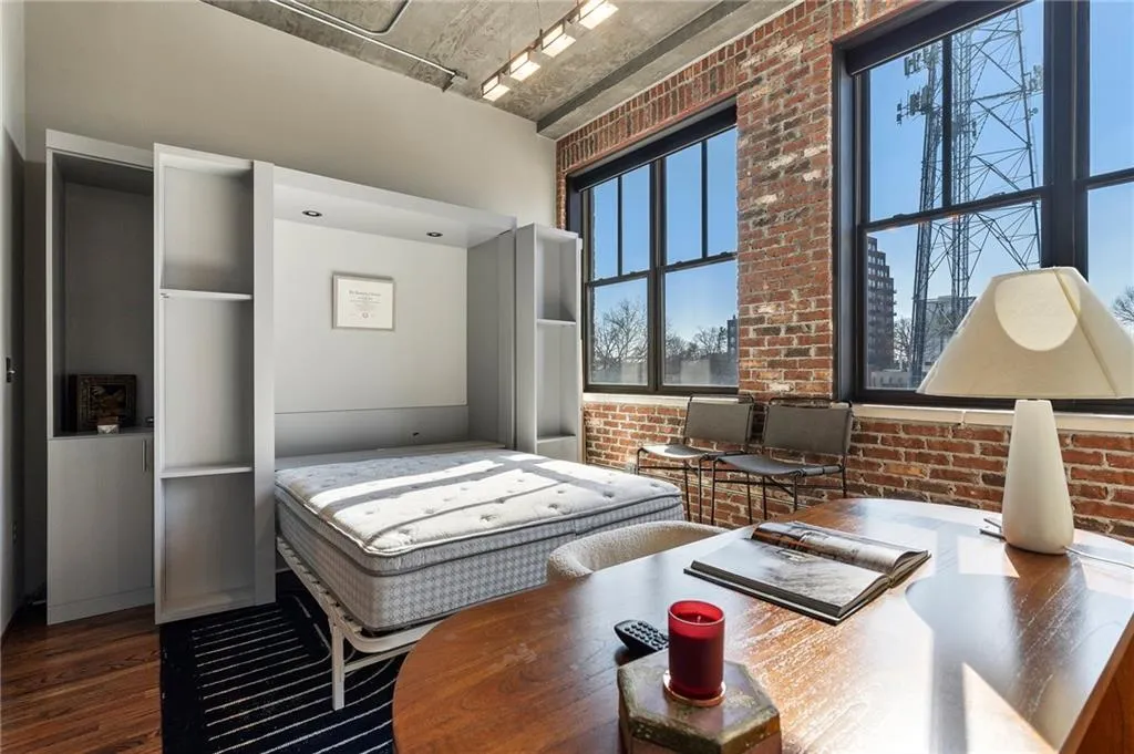 Bedroom featuring brick wall and hardwood / wood-style floors