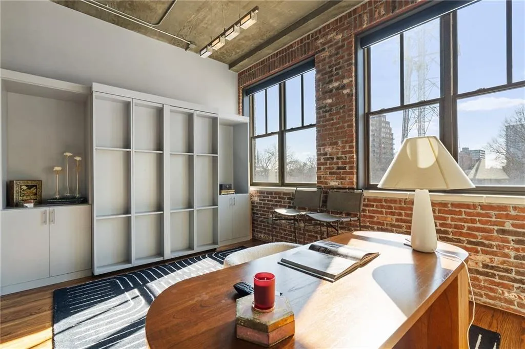 Office area with track lighting, brick wall, and hardwood / wood-style floors