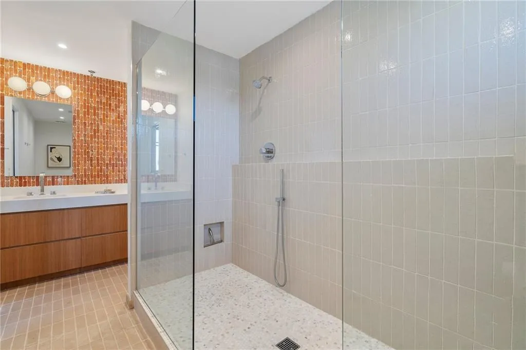 Bathroom with tile patterned floors, vanity, and a tile shower