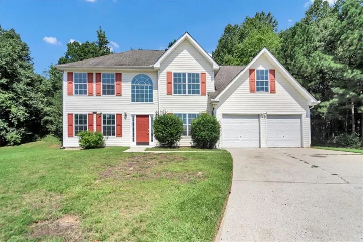 Two-story exterior with vinyl siding, red paneled shutters, a prominent arch window, and an attached two-car garage