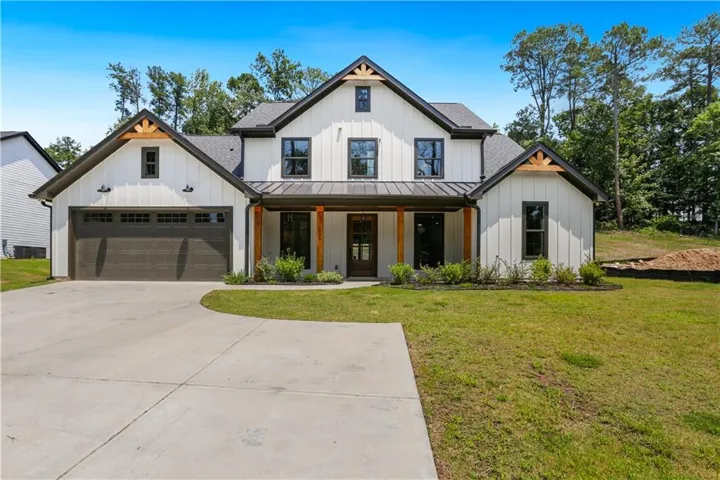 Contemporary farmhouse exterior featuring white board and batten siding with dark trim accents