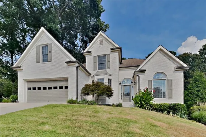 Brick exterior with contrasting shutters and a prominent arched entryway