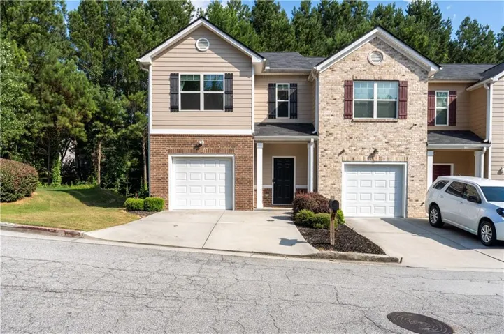 Townhome exterior featuring brick and siding facade, individual garage, and a covered entry