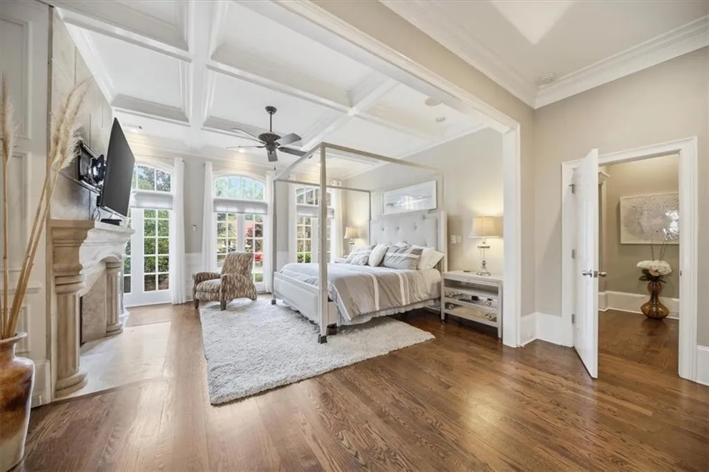 Primary Bedroom on the main with lots of windows, coffered ceilings, and the 3rd of the 6 Fireplaces in this home.