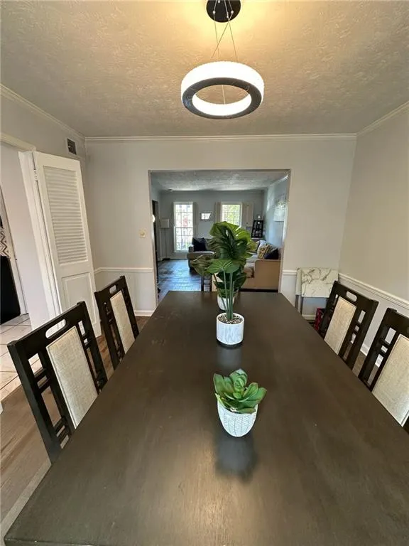 Dining space featuring a textured ceiling and crown molding