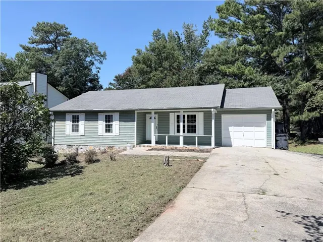 Exterior featuring horizontal siding, white shutters, a covered porch, and an attached single-bay garage