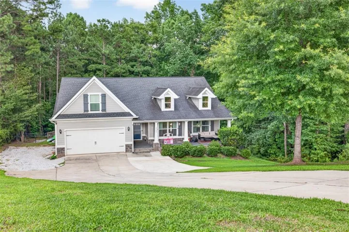 Craftsman-style home featuring gray siding, a prominent gable, and a two-car garage