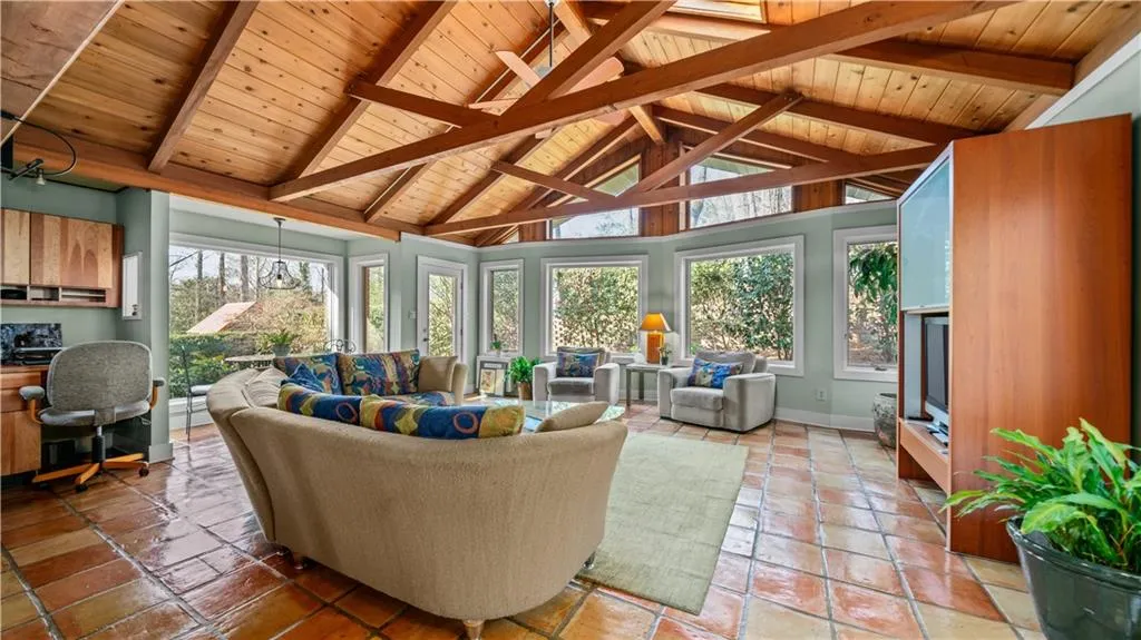 Sunroom featuring lofted ceiling with beams and wooden ceiling