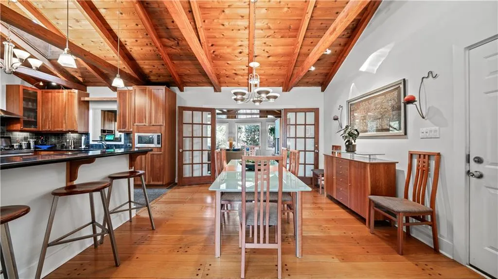 Dining space featuring wood ceiling, light hardwood / wood-style floors, a notable chandelier, and french doors