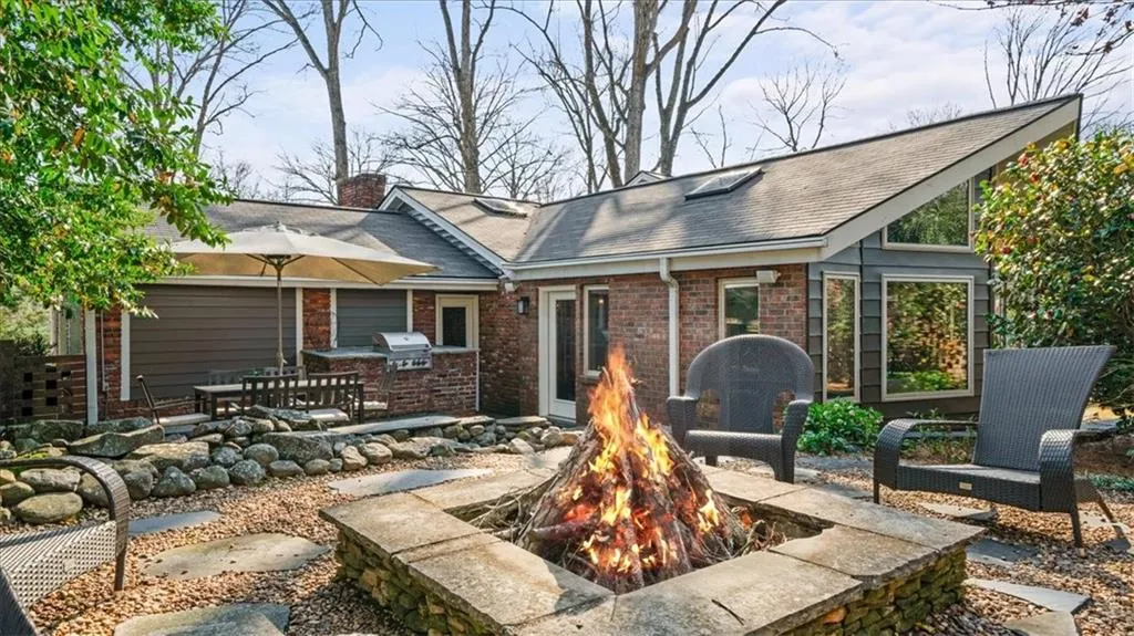 Rear view of house with a patio and an outdoor fire pit