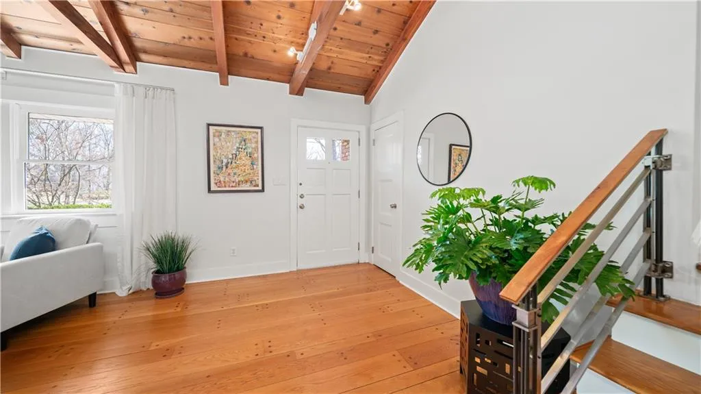 Entrance foyer with wooden ceiling, lofted ceiling with beams, and light hardwood / wood-style floors