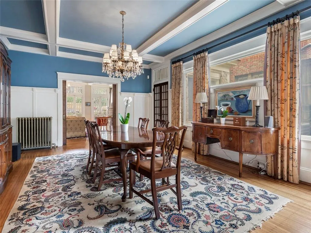 Dining area featuring a chandelier, coffered ceiling, wood finished floors, beam ceiling, and radiator heating unit