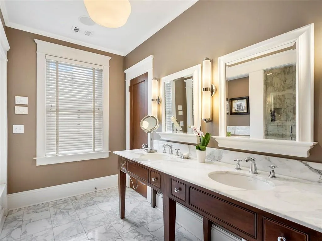 Full bathroom with crown molding, marble finish floor, a sink, and baseboards
