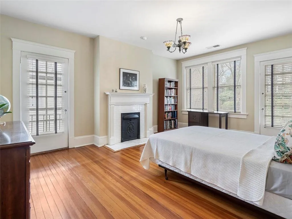 Bedroom featuring a notable chandelier, a fireplace, visible vents, access to outside, and light wood finished floors