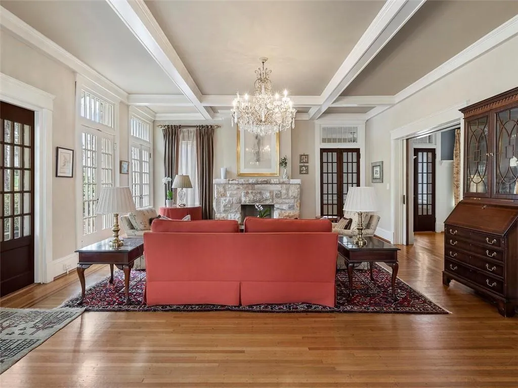 Living area featuring coffered ceiling, a fireplace, beamed ceiling, and wood finished floors