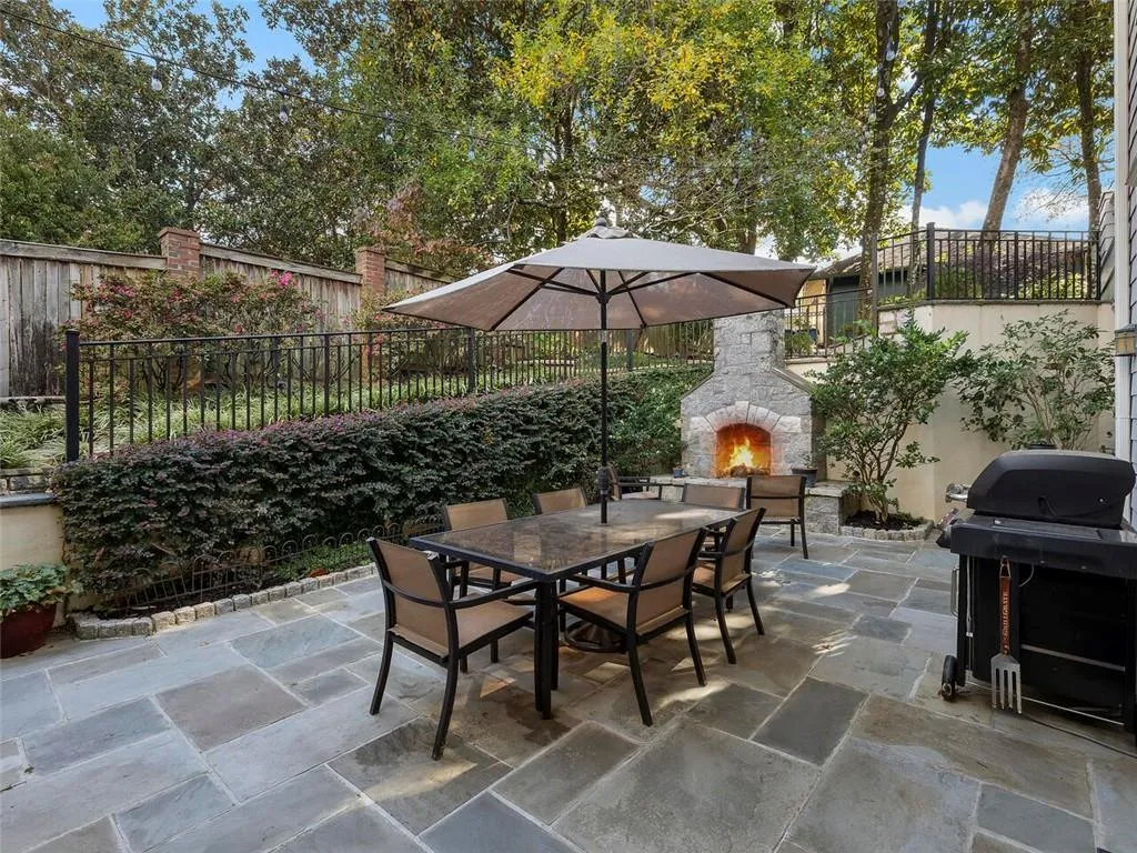 View of patio / terrace featuring outdoor dining space, an outdoor stone fireplace, grilling area, and a fenced backyard