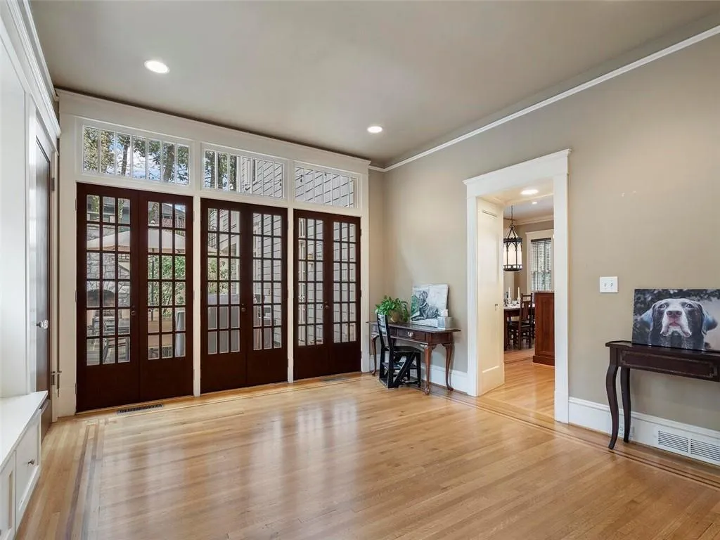 Doorway with light wood-type flooring, french doors, and crown molding