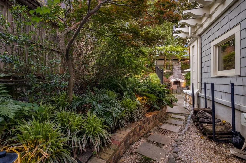 View of yard with an outdoor fireplace and fence