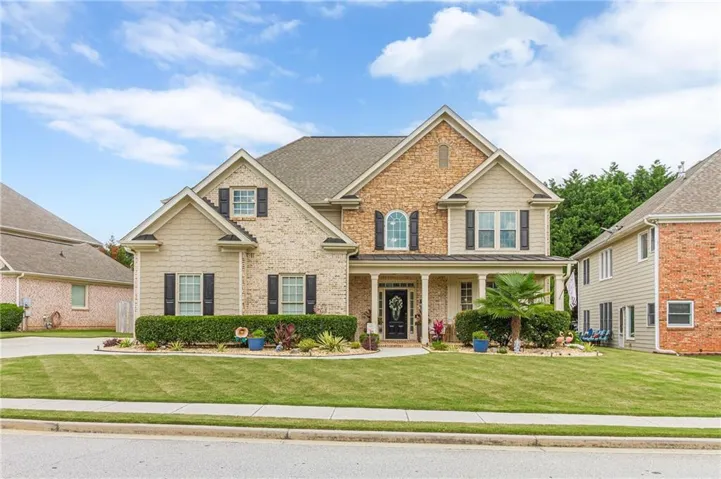 Traditional two-story residence featuring a brick and siding facade with black louvered shutters