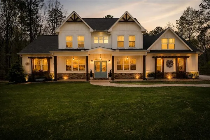 Two-story farmhouse exterior with board and batten siding and stone accents