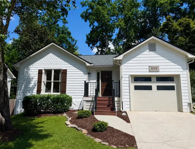 White siding exterior with a dark brown entry door and garage door