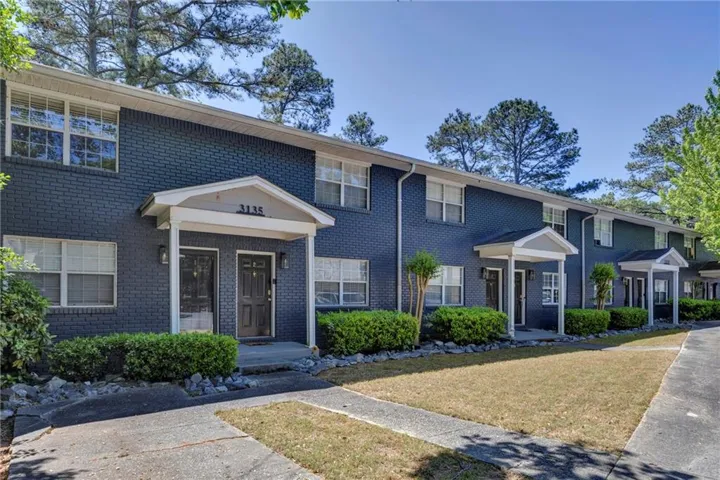 Multi-unit residence featuring a dark brick exterior and white window trim