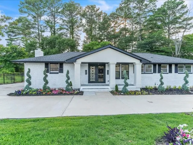 White brick facade with black trim accents and a contrasting dark roof