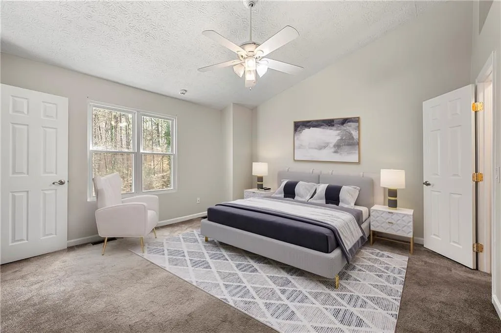 Carpeted bedroom with a ceiling fan, baseboards, vaulted ceiling, and a textured ceiling