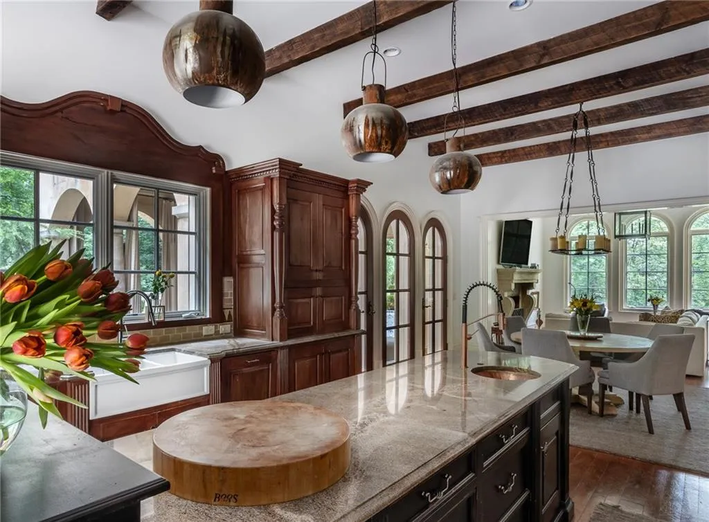 Kitchen featuring high end appliances, light stone countertops, backsplash, a center island with sink, and hardwood / mahogany wood-style flooring