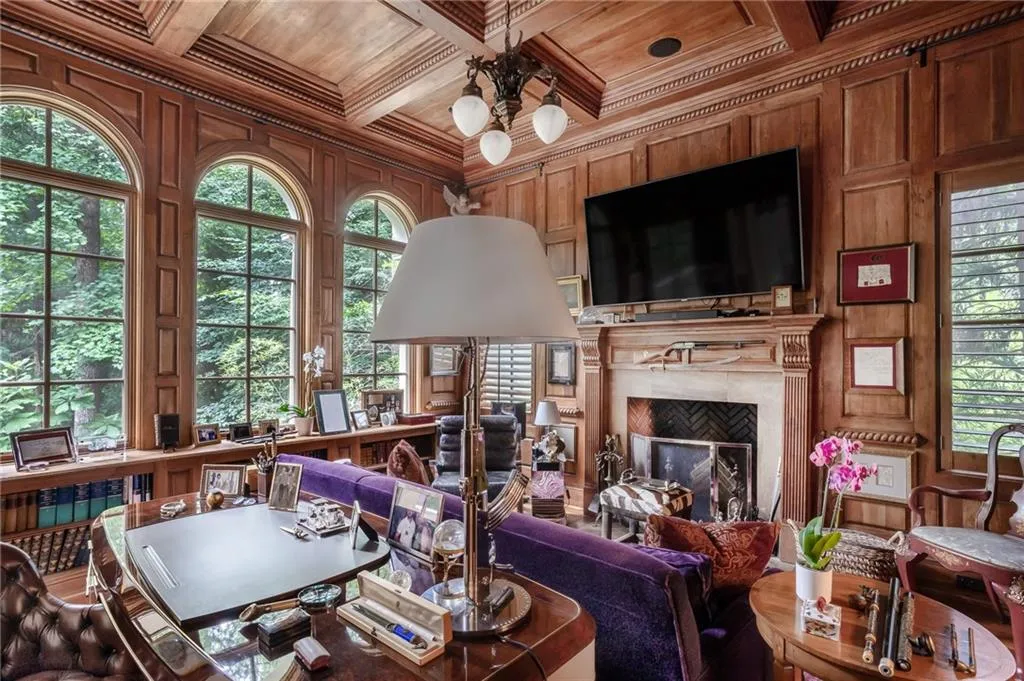 Library with living area with a high end fireplace, wood ceiling, crown molding, wood walls, and mahogany wood flooring