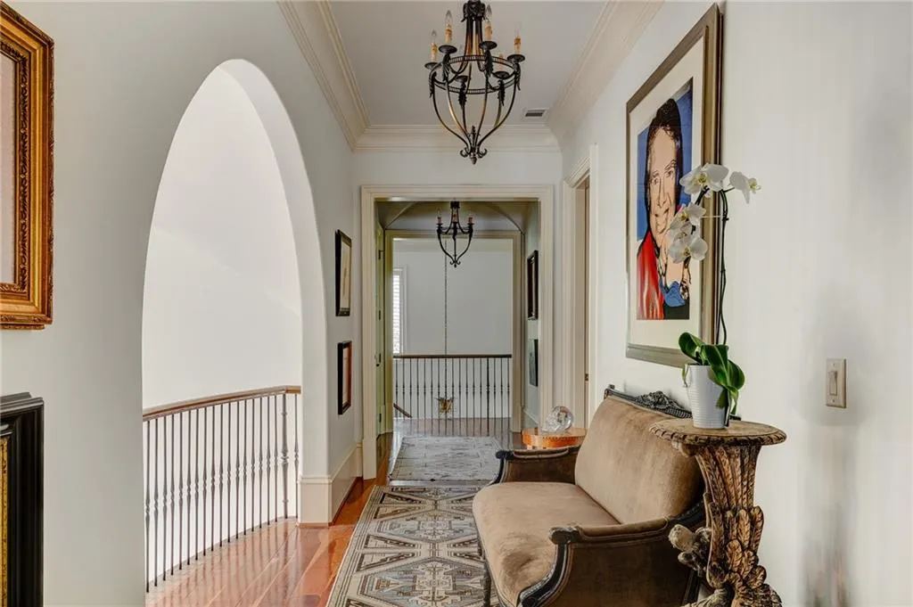 Hallway with hardwood / wood-style flooring, a chandelier, and molding
