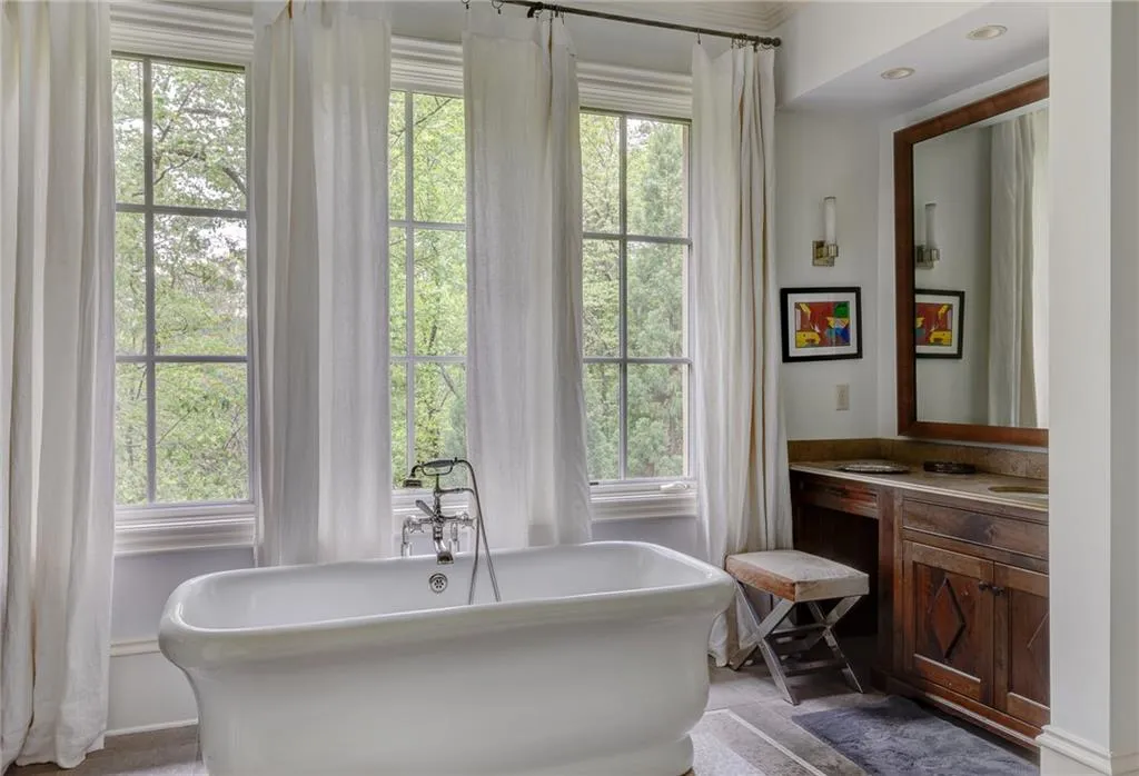 Primary bathroom featuring a healthy amount of sunlight, a bathing tub, and vanity