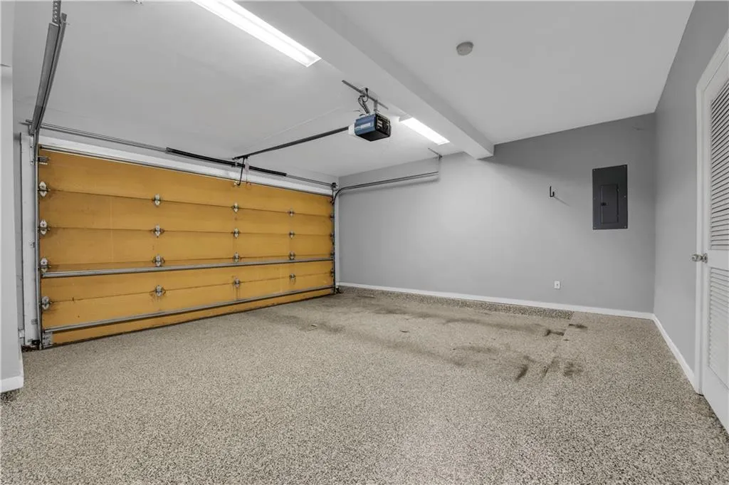 Garage with a light gray wall finish, a two-car garage door, and a textured floor coating