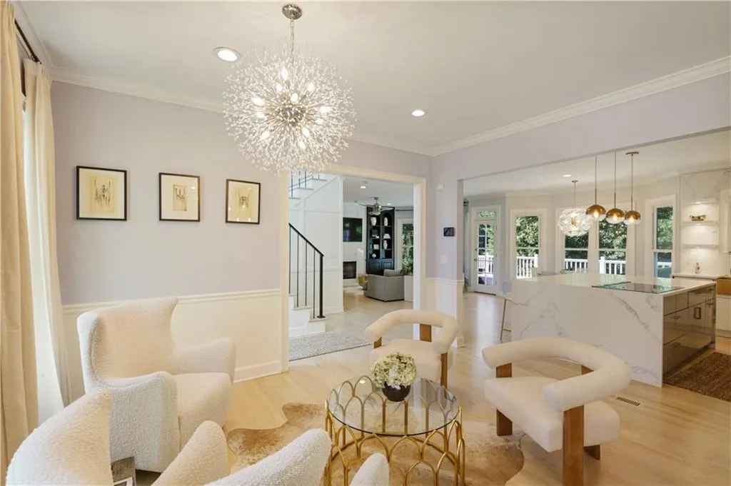 Living room featuring ornamental molding, an inviting chandelier, and light wood-type flooring