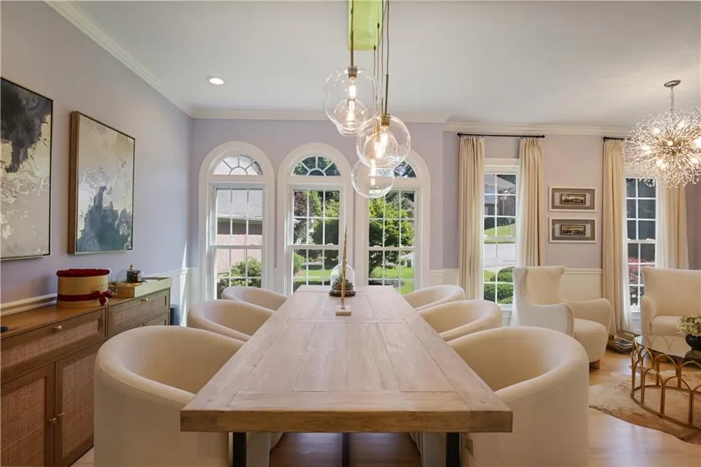 Dining room with a notable chandelier, hardwood / wood-style floors, plenty of natural light, and crown molding