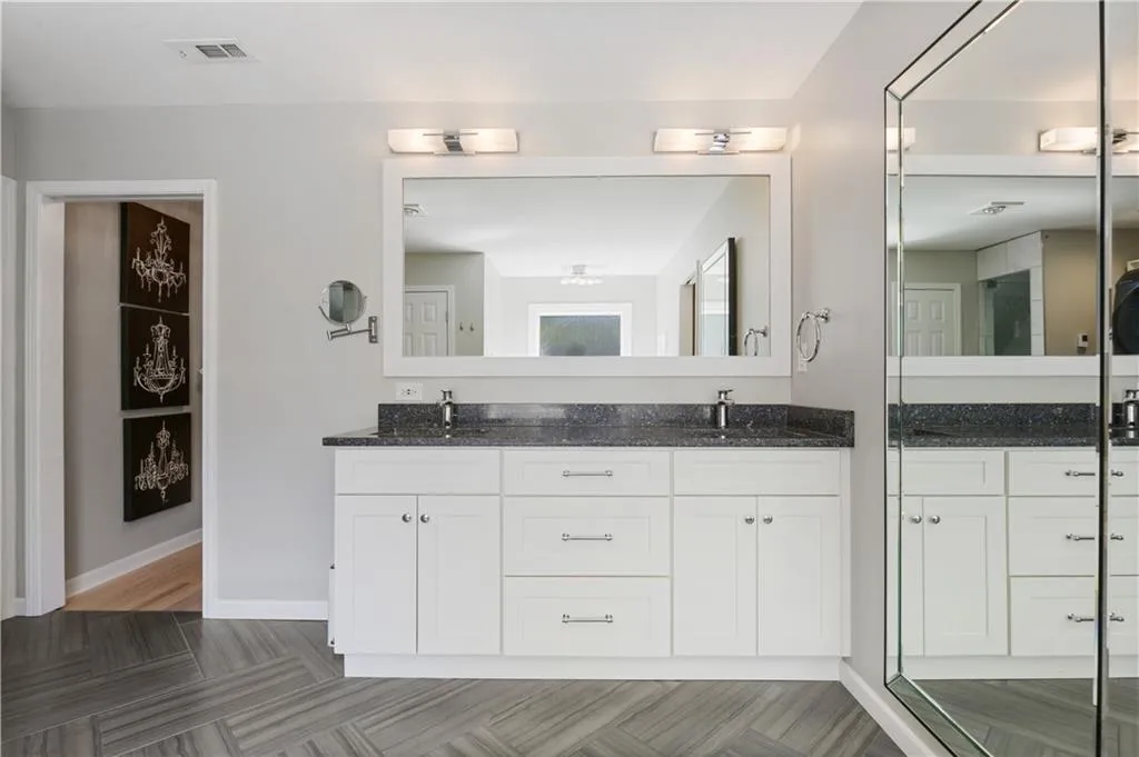 Bathroom with walk in shower, double vanity, and wood-type flooring