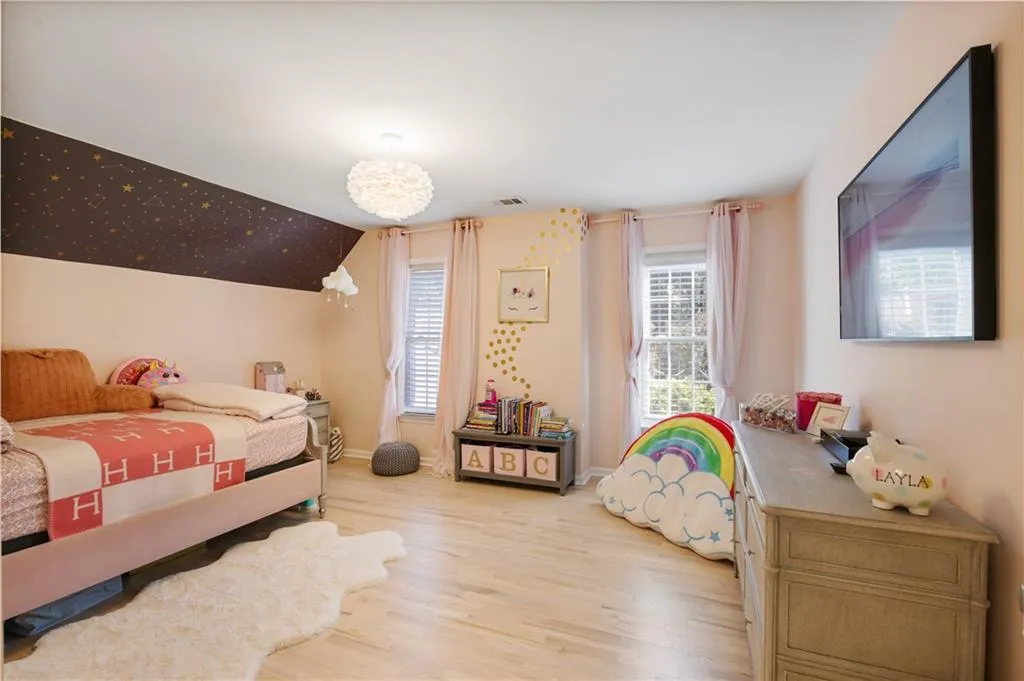 Bedroom featuring multiple windows and light hardwood / wood-style flooring