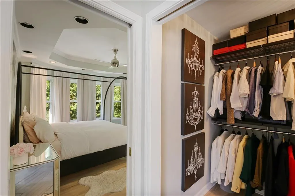 Bedroom featuring a closet, a tray ceiling, crown molding, and hardwood / wood-style flooring